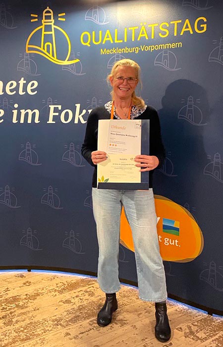 Frau mit der Auszeichnung beim Qualitätstag